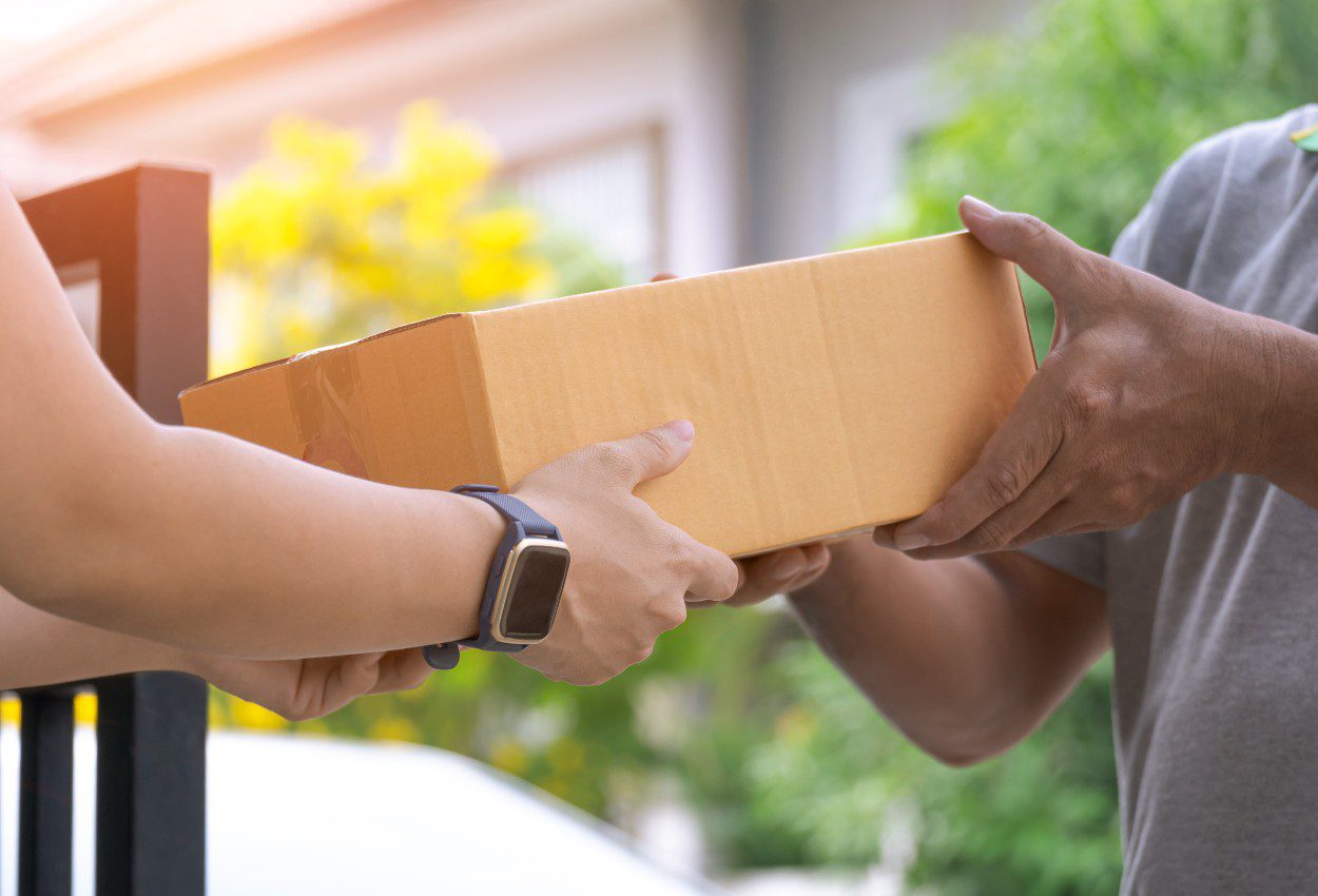 mujer-joven-que-recibe-una-caja-de-paquetes-del-repartidor